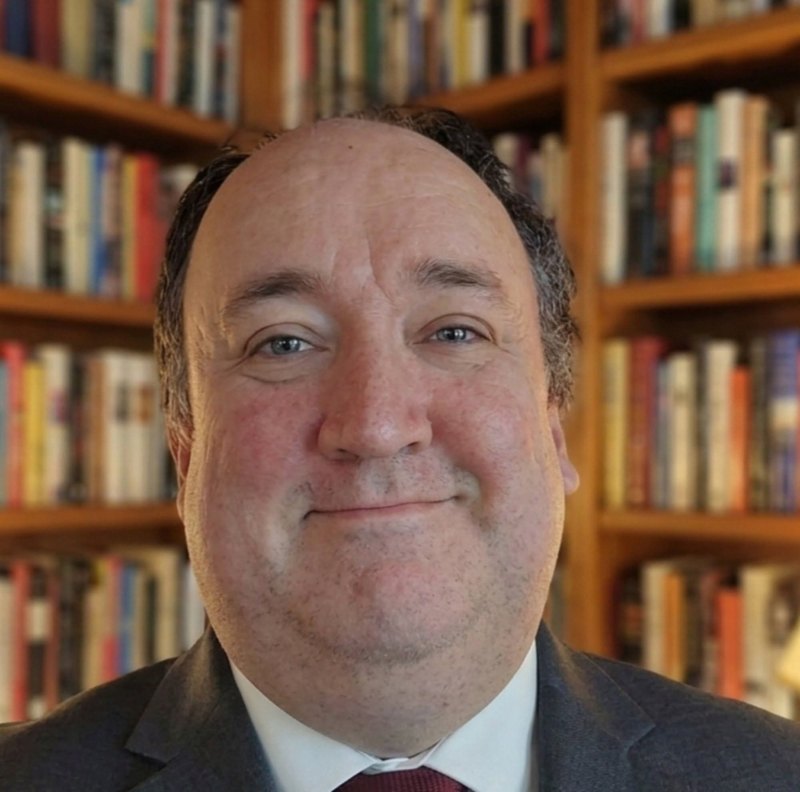 Cory Tarwater, children's book author, in front of a bookshelf
